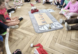 Dzieci siedzą w kręgu i rozmawiają o atrybutach Mikołaja