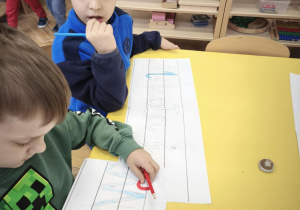 Starszak wykonuje napis Mikołaj z ruchomego alfabetu