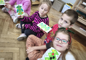 Dzieci pokazują otrzymane od kolegów świąteczne kartki