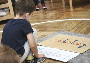 Starszak wykonuje napis Mikołaj z ruchomego alfabetu