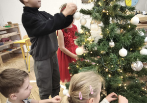 Dzieci ubierają choinkę