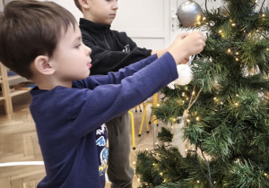 Dzieci ubierają choinkę