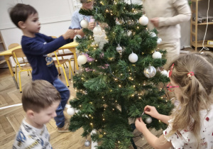 Dzieci ubierają choinkę