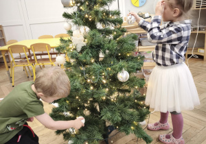 Dzieci ubierają choinkę