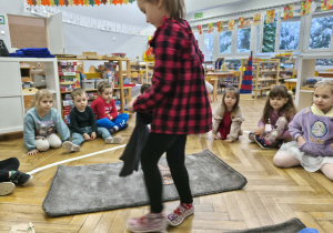 Na zdjęciu widzimy dziewczynkę, która trzyma w ręku podkoszulkę.