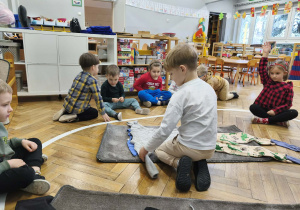 Na zdjęciu widzimy chłopca, który ubiera niewidzialnego Tadka w sweter.