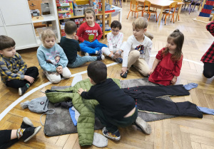 Na zdjęciu widzimy chłopca, który ubiera niewidzialnego Tadka w kurtkę.