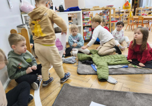 Na zdjęciu widzimy chłopca, który dopasowuje ilustrację czapki do ubioru.