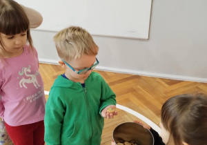 Dzieci częstują się ciasteczkami.