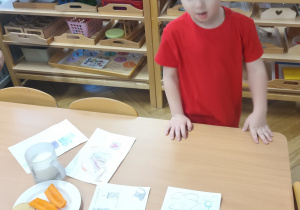 Chłopiec kładzie list do Mikołaja na stole.