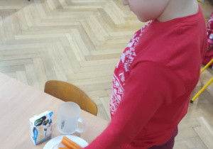 Chłopiec układa ciastka na talerzu.