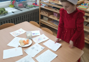 Dziewczynka kładzie list do Mikołaja na stole.