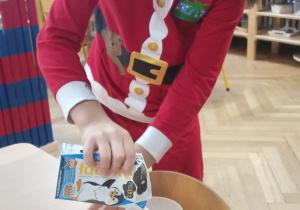 Dziewczynka nalewa mleka do szklanki.