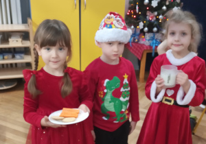 Dzieci niosą niespodziankę dla Mikołaja.