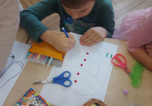 chłopiec projektujący sweterek