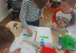 chłopiec projektujący sweterek