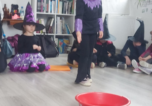 dziewczynka wrzuca pieniążek do miski z wodą