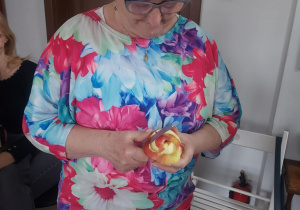 seniorka obierająca jabłko, liczy się długość skórki