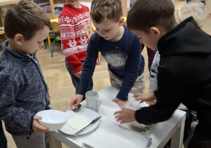 chłopcy nakrywają stół wigilijny