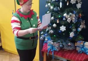 Nauczyciel czyta list, a dzieci siedzą w kole.