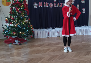 Pani Mikołajowa mówi przez mikrofon.