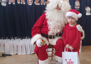 Dziewczynka stoi koło Mikołaja.
