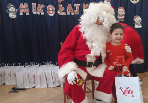 Chłopiec stoi koło Mikołaja.