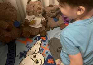 Na zdjęciu widzimy chłopca, który porządkuje swój pokój.