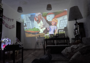 Na zdjęciu widzimy dziewczynkę, która ogląda bajkę zimową.