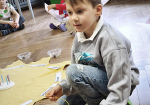 Chłopiec nawleka łańcuch życia