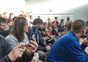 Rodzice siedzący na krzesełkach, oglądający występ