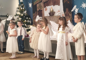 Dzieci występują w strojach aniołków . kolejno mówią swoje role
