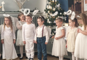 Dzieci występują w strojach aniołków . kolejno mówią swoje role