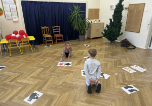 Zdjęcie przedstawia dziewczynkę dobierającą obrazek do cienia, podczas działań na podłodze.