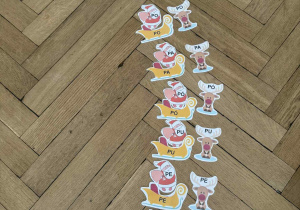 Zdjęcie przedstawia ułożone sanie z reniferami i Mikołajem z określonymi sylabami.