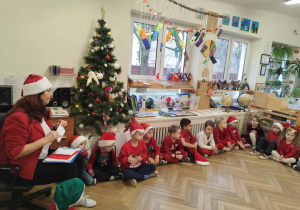 Nauczyciel czyta dzieciom list od Mikołaja