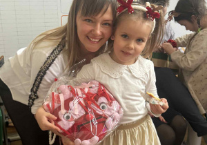 Zdjęcie przedstawia kobietę z dziewczynką, która w ręku trzyma swojego Smutkozjadka.