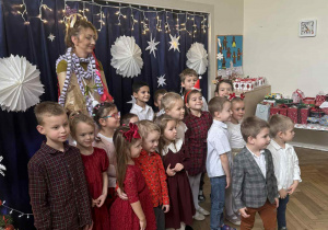 Zdjęcie przedstawia dzieci z kobietą, przebraną za choinkę.