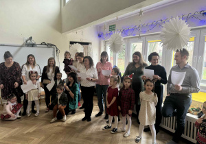 Zdjęcie przedstawia rodziców z tekstami w ręku, przygotowujących się do występu.