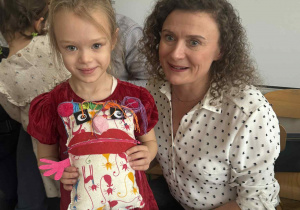 Zdjęcie przedstawia kobietę z dziewczynką, która w ręku trzyma swojego Smutkozjadka.