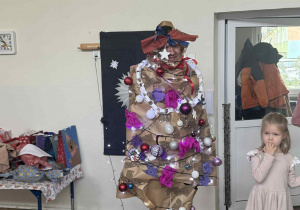 Zdjęcie przedstawia mężczyznę przebranego za choinkę.