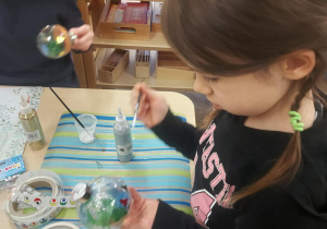 dziewczynka malująca bombkę