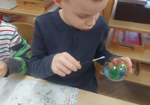 chłopiec malujący bombkę