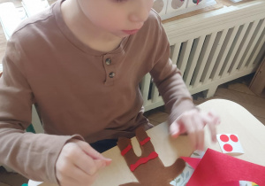 chłopiec wykonuje piernikowego ciastka z filcu