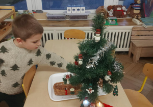 chłopiec ubiera choinkę