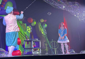 Zdjęcie przedstawia aktora tworzącego duże bańki.