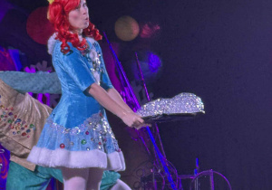 Zdjęcie przedstawia aktorkę trzymającą tacę z pianą- bańkami.