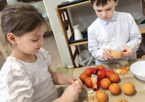 Dzieci obierają i układają owoce