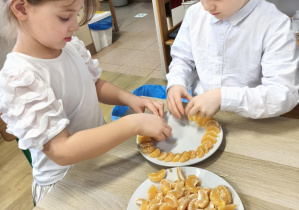 Dzieci obierają i układają owoce