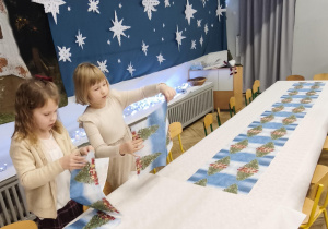Dzieci nakrywają do stołu wigilijneg